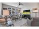 Comfortable living room with large windows, ceiling fan, stylish furniture, and entertainment center with large TV at 4100 S Pinelake Way # 143, Chandler, AZ 85249