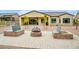 Paver patio with fire pit and built-in bench seating in landscaped backyard at 41622 W Summer Sun Ln, Maricopa, AZ 85138