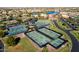 Aerial view of tennis courts in a well-maintained community, surrounded by lush greenery and scenic views at 41622 W Summer Sun Ln, Maricopa, AZ 85138