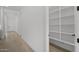 Bright hallway with hardwood floors and view of a walk-in pantry with shelves and lighting at 4210 E Desert Vista Trl, Cave Creek, AZ 85331