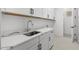 Clean and modern laundry room with white cabinetry, quartz countertops, and stainless steel fixtures at 4210 E Desert Vista Trl, Cave Creek, AZ 85331