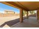Covered back porch overlooking a large yard, providing space for outdoor seating and entertainment at 43608 W Kristal Ln, Maricopa, AZ 85138