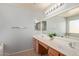 Bathroom featuring double sinks, a large mirror, and stylish fixtures at 43608 W Kristal Ln, Maricopa, AZ 85138