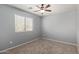Bright bedroom featuring carpet flooring, a ceiling fan and ample natural light at 43608 W Kristal Ln, Maricopa, AZ 85138