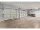 Spacious three car garage with concrete floors and white doors; ample room for vehicles and storage at 43608 W Kristal Ln, Maricopa, AZ 85138