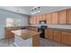 Modern kitchen featuring granite countertops, wood cabinetry and a center island with sink at 43608 W Kristal Ln, Maricopa, AZ 85138