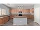 A well-equipped kitchen features wood cabinets, granite countertops, and a center island at 43608 W Kristal Ln, Maricopa, AZ 85138