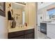 Powder room featuring a vanity with decorative vase, mirror, and access to the laundry area at 43638 N 22Nd St, New River, AZ 85087