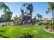 Beautifully landscaped community entrance with a globe statue and water feature, creating a serene ambiance at 54 Leisure World --, Mesa, AZ 85206