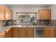 Beautiful kitchen featuring stainless steel sink, wooden cabinets, and mosaic backsplash at 54 Leisure World --, Mesa, AZ 85206