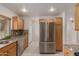 Bright kitchen featuring stainless steel refrigerator and sink with wooden cabinets at 54 Leisure World --, Mesa, AZ 85206