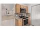 Modern kitchen with stainless steel appliances, a view into the Gathering room, and wooden cabinets at 54 Leisure World --, Mesa, AZ 85206