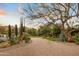 Scenic driveway lined with lush greenery, desert landscaping, and mature trees leading to the property at 6640 E Kasba Cir, Paradise Valley, AZ 85253