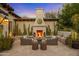 Inviting outdoor patio featuring a stone fireplace, comfortable seating, and serene desert landscaping at 6640 E Kasba Cir, Paradise Valley, AZ 85253