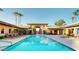 Resort-style community pool featuring lounge chairs, lush palm trees, and beautiful common areas at 7009 E Acoma Dr # 1113, Scottsdale, AZ 85254