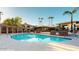 Large community pool with plenty of lounge chairs, umbrellas, and lush palm trees at 7009 E Acoma Dr # 1113, Scottsdale, AZ 85254