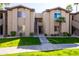 Exterior of condo building with neatly trimmed green grass, palm trees, and neutral-colored facade at 7009 E Acoma Dr # 1113, Scottsdale, AZ 85254