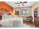 Comfortable main bedroom with wooden floors, a ceiling fan, and a built-in desk near closet at 7009 E Acoma Dr # 1113, Scottsdale, AZ 85254