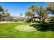 Community putting green with manicured lawn, mature trees, and resort-style building in the background at 7009 E Acoma Dr # 1113, Scottsdale, AZ 85254