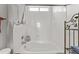 Clean tub shower with white tile surround, a shower curtain rod, and built in shelves at 7009 E Acoma Dr # 1113, Scottsdale, AZ 85254