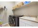 Well-organized laundry room with a modern washer and dryer, built-in shelving, a utility sink, and ample storage space at 7370 E Sunset Sky Cir, Scottsdale, AZ 85266