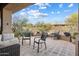Charming backyard patio with brick flooring and plentiful seating for entertaining against a backdrop of natural desert foliage at 7370 E Sunset Sky Cir, Scottsdale, AZ 85266