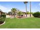 Backyard showcasing green lawn, desert landscaping, a cabana and pool area perfect for relaxation and outdoor gatherings at 7820 S Maple Ave, Tempe, AZ 85284