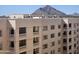 Exterior view of a beige condo building with multiple balconies against a mountain backdrop at 7940 E Camelback Rd # 712, Scottsdale, AZ 85251