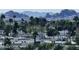 A community view from a building shows lush trees, roof tops, and mountain views at 7940 E Camelback Rd # 712, Scottsdale, AZ 85251