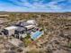 Aerial view of a desert estate featuring an outdoor pool, patio, and luxurious landscaping in a scenic setting at 8145 E Tecolote Cir, Scottsdale, AZ 85266