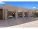 Wide angle view of the three car garage and driveway with stone columns at 8145 E Tecolote Cir, Scottsdale, AZ 85266