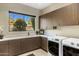 Well-organized laundry room with front-loading washer/dryer, ample cabinets, and natural light at 8145 E Tecolote Cir, Scottsdale, AZ 85266