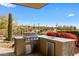 Outdoor kitchen with a built-in grill, countertop space, and a refrigerator, perfect for outdoor cooking and entertaining at 8145 E Tecolote Cir, Scottsdale, AZ 85266