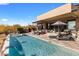 Inviting swimming pool with lounge chairs and umbrellas, set against the backdrop of the desert landscape and modern architecture at 8145 E Tecolote Cir, Scottsdale, AZ 85266