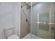 Bathroom with tiled shower featuring glass door, neutral tiles and modern shower head at 9115 E Purdue Ave # 107, Scottsdale, AZ 85258