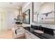 Bright bathroom showcasing a soaking tub, dual vanities with black countertops, and modern fixtures at 9270 E Thompson Peak Pkwy # 370, Scottsdale, AZ 85255