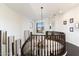 Bright upper foyer features a dark wood banister and a modern chandelier at 9270 E Thompson Peak Pkwy # 370, Scottsdale, AZ 85255