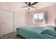 Bedroom with pink walls, ceiling fan, and sliding door closet at 951 W La Jolla Dr, Tempe, AZ 85282