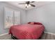 Bedroom with grey-blue walls, ceiling fan, and large window with white blinds at 951 W La Jolla Dr, Tempe, AZ 85282