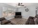 Cozy living room with new flooring, a ceiling fan, and bright natural light from large windows at 951 W La Jolla Dr, Tempe, AZ 85282