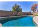 Inviting pool with clear blue water, surrounded by a block wall and green grass at 951 W La Jolla Dr, Tempe, AZ 85282