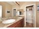 Bathroom featuring double sinks with granite countertops and wood cabinets at 9901 E Bahia Dr, Scottsdale, AZ 85260