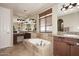 Bathroom featuring a soaking tub with travertine tile surround and double sink vanities and granite countertop at 9901 E Bahia Dr, Scottsdale, AZ 85260