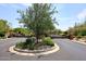 Community entrance with meticulously landscaped median with beautiful mature trees at 9901 E Bahia Dr, Scottsdale, AZ 85260