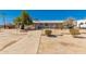 A desert property with a weathered walkway and minimal landscaping under a clear sky at 1015 N 193Rd Ave, Buckeye, AZ 85326