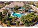 A landscaped yard featuring a pool, slide, umbrellas, lush landscaping, a covered structure, and elegant seating at 10417 N 180Th Dr, Waddell, AZ 85355