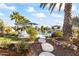 Beautifully landscaped backyard featuring stone walkway, plants, and pool in the distance at 10417 N 180Th Dr, Waddell, AZ 85355