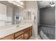 Bathroom features a vanity with sink, mirror, and doorway to carpeted bedroom at 10417 N 180Th Dr, Waddell, AZ 85355