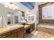 Bathroom featuring a large mirror, dual sinks, and a bathtub shower combination at 10417 N 180Th Dr, Waddell, AZ 85355