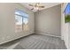 Cozy bedroom with natural light, ceiling fan, neutral gray walls and plush carpet at 10417 N 180Th Dr, Waddell, AZ 85355